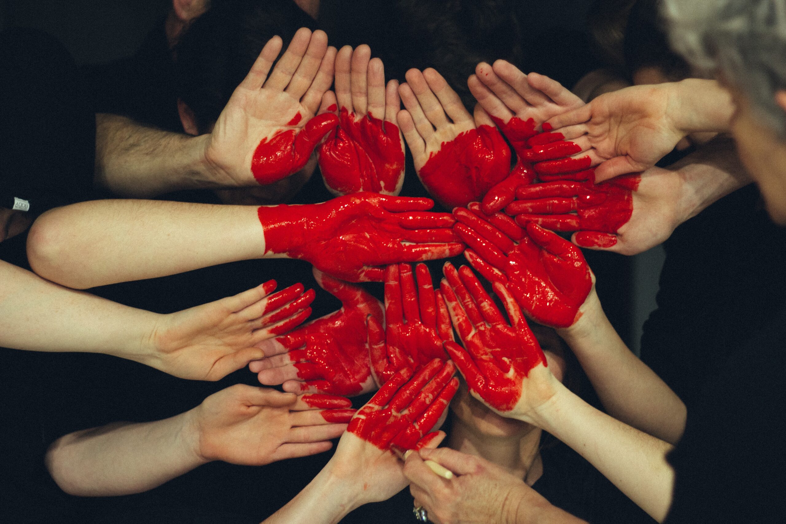 Volunteers' hands put together, making the shape of a heart.