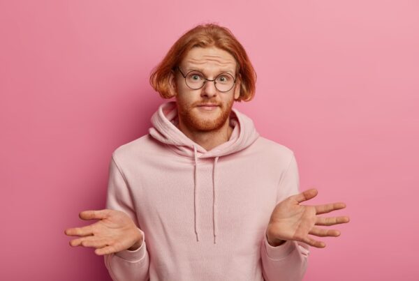 How to write a good cover letter? A ginger man in a pink sweatshirt looking confused.