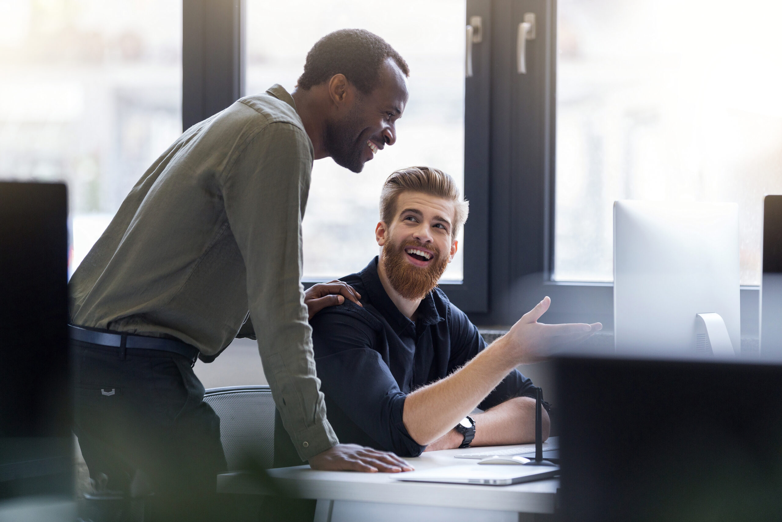 Two happy smiling men working together on a new business project of deta-vast employment